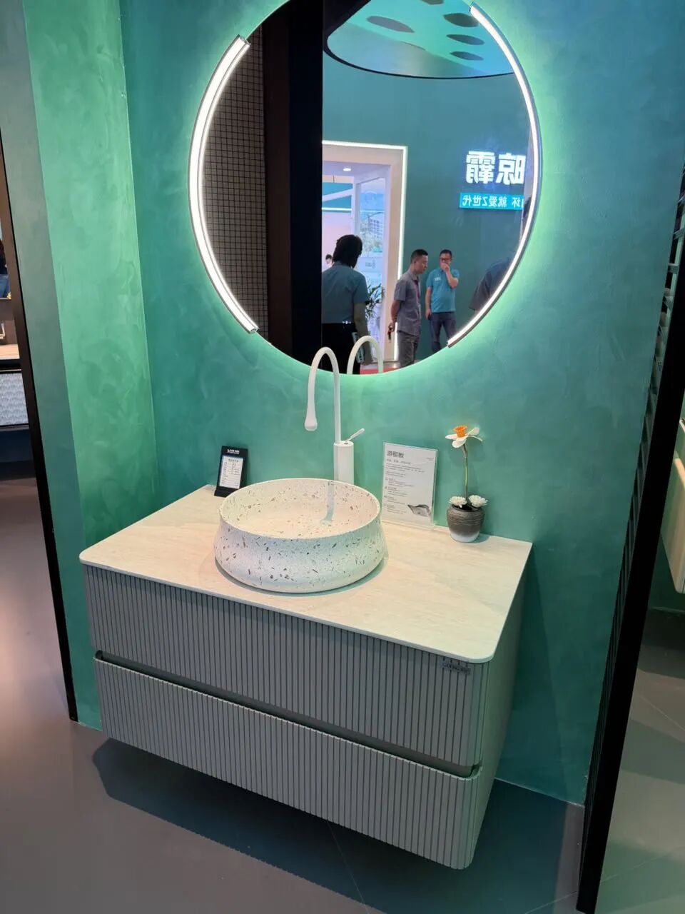 Modern bathroom vanity with wood-grain cabinet, stone countertop, and round mirror at 2026 Shanghai KBC Expo
